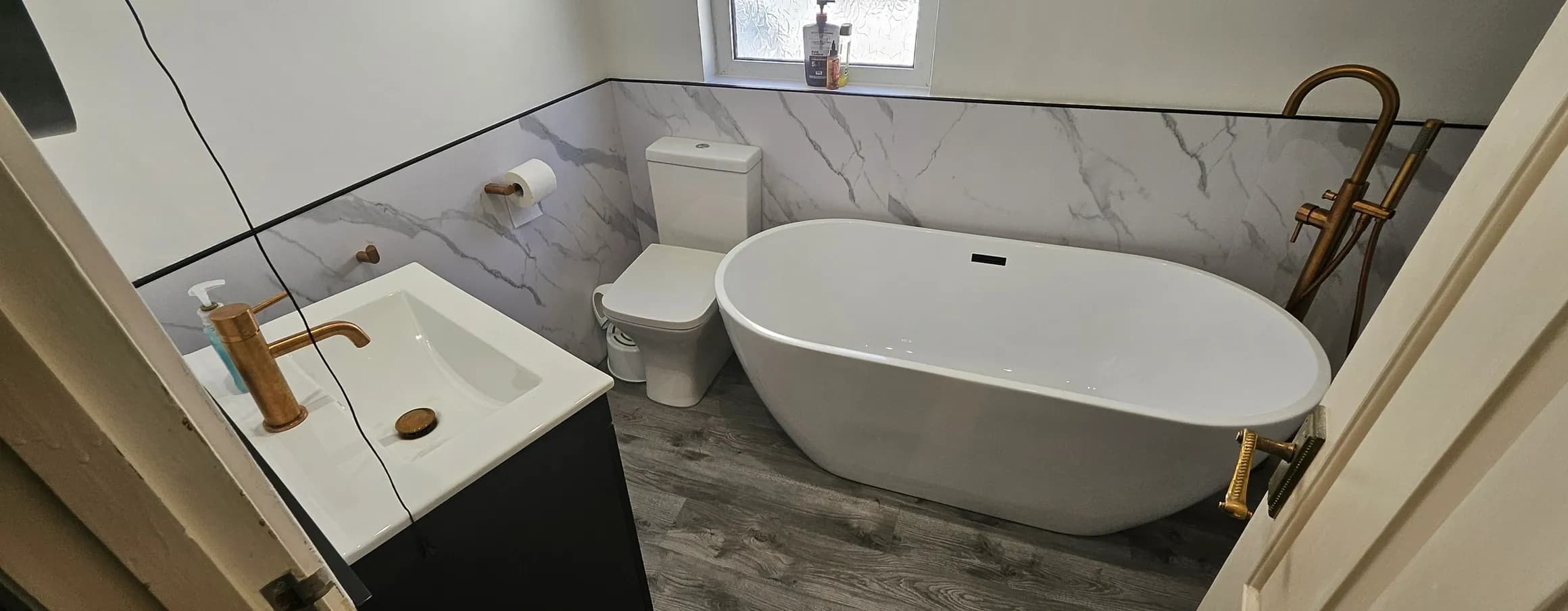 Luxury bathroom with marble cladding and freestanding bath